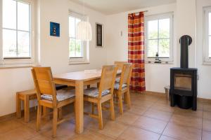 a dining room with a table and a wood stove at C 5 Premium Reethaus Delphin mit eigenem Whirlpool und Außensauna in Gramkow