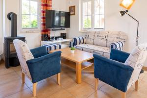 a living room with a couch and a table and chairs at C 5 Premium Reethaus Delphin mit eigenem Whirlpool und Außensauna in Gramkow