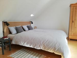 a bedroom with a white bed with a wooden headboard at Familienzeit - aktuell noch freie Kapazitäten im Sommer! in Riepsdorf