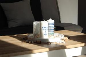 StickHaus 4711 rechtes Haus in Tossens的一张桌子上放着两根蜡烛和贝壳