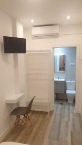 W łazience znajduje się toaleta, biurko i krzesło. w obiekcie Hostal royal begoña w Madrycie