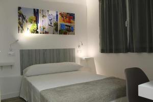 sypialnia z łóżkiem i obrazem na ścianie w obiekcie Hostal royal begoña w Madrycie
