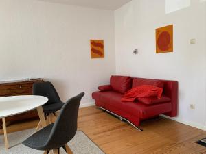 a living room with a red couch and a table at Ferienwohnung in der Schleife in Rendsburg