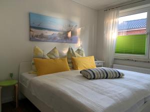a bedroom with a bed with yellow pillows and a window at Ferienwohnung in der Schleife in Rendsburg