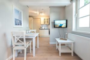 UtersumにあるLandhaus am Meer - Whg 3 Liinsandのテーブルと壁掛けテレビのあるダイニングルーム