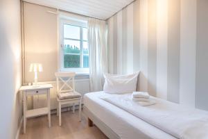 UtersumにあるLandhaus am Meer - Whg 3 Liinsandのベッドと窓のある小さな寝室 +2枚の写真