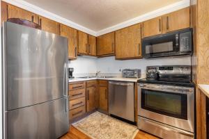 a kitchen with stainless steel appliances and wooden cabinets at Epic Condo walk to Canyon Lodge in Mammoth Lakes