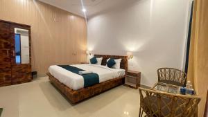 a bedroom with a large bed and a chair at GreenDay Escapes Rishikesh in Rishīkesh