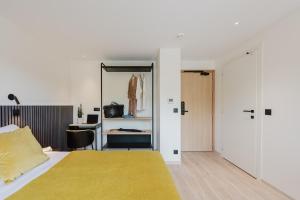 a bedroom with a bed and a desk with a mirror at Appart Hotel Neostelia in Annecy