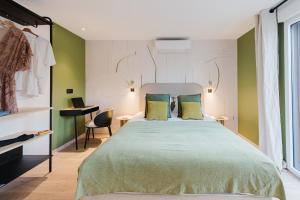 a bedroom with a large bed with green walls at Appart Hotel Neostelia in Annecy