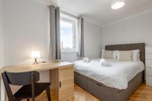 a bedroom with a desk and a bed and a window at Spire View Apartment in St. Andrews