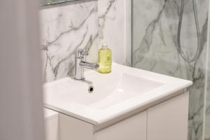 a white bathroom sink with a soap bottle on it at Spire View Apartment in St. Andrews +13 photos