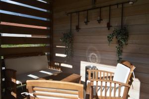 a patio with two chairs and a table and a bench at Chalet de la Royotte - Sauna & SPA in Gérardmer