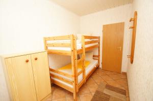 Zimmer mit 2 Etagenbetten und einer Tür in der Unterkunft "Haus Stefanie" Bungalow -2- in Dahme
