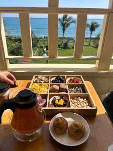 a tray of pastries on a table with a tea pot and a plate at 近月旭海莊園民宿 in Yanliau +87 photos