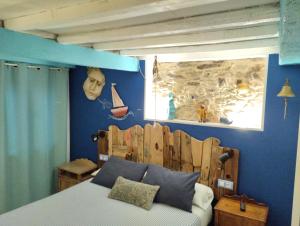 a bedroom with a bed with a wooden head board at Casa Apilladeira in Puentedeume