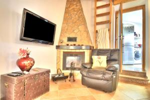 a living room with a chair and a fireplace at BeGuest Alcantarilha Family Home in Alcantarilha