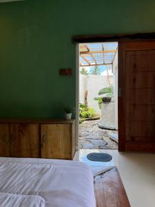 a bedroom with a bed and a green wall at kunang kunang in Tetebatu