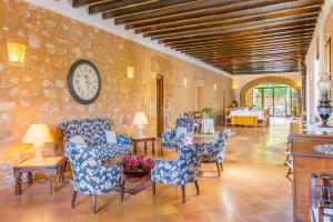 a living room with chairs and a clock on the wall at Historical house Mallorca pool wifi airconheat in Andratx +17 photos