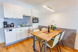 kuchnia z drewnianym stołem i białymi szafkami w obiekcie Happy Aich 1 by Alpenidyll Apartments w mieście Aich