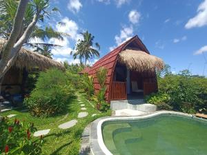 a resort with a swimming pool and a hut at One Bali Villa in Bangli