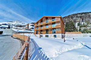 a building in the snow with snow covered ground at Chesa Muntanella - Samedan in Samedan