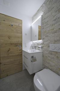a bathroom with a toilet and a sink and a mirror at Chesa Muntanella - Samedan in Samedan +14 photos
