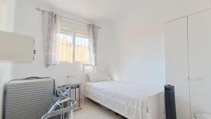 a white room with a bed and a window at La Siesta Perfecta in Villacosta