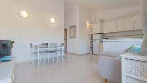 a living room with a couch and a table with chairs at La Siesta Perfecta in Villacosta +3 photos