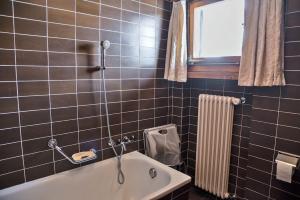 un bagno con vasca e finestra di Chesa Dal Gial - Celerina a Celerina