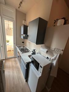 a kitchen with a stove and a microwave at Casa di Otti in Ivrea