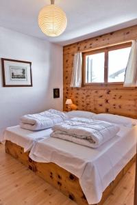 2 letti in una camera da letto con parete in legno di Chesa Dal Gial - Celerina a Celerina