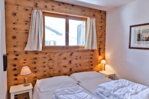 una camera da letto con due letti e una finestra di Chesa Dal Gial - Celerina a Celerina