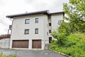 a white building with two garage doors at Chesa Martina - La Punt in La Punt-Chamues-ch