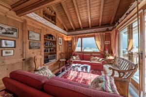 a living room with a red couch and a table at Chesa La Buot - Silvaplana in Silvaplana