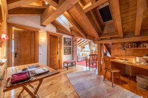 a kitchen with wooden ceilings and a wooden table at Chesa La Buot - Silvaplana in Silvaplana