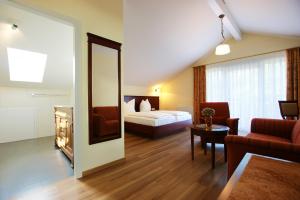 バーデン・バーデンにあるWaldcafé Hotel Restaurantのベッドとリビングルームが備わるホテルルームです。
