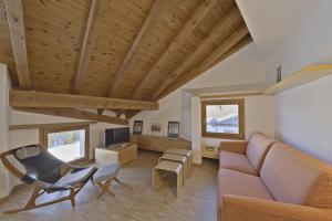 a living room with a couch and a chair at Chesa Pitz Alv - Pontresina in Pontresina