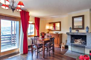 a dining room with a table and a fireplace at Chesa Trisur - Celerina in Celerina