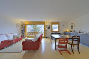 a living room with a red couch and a table at Chesa Ladina - Zuoz in Zuoz