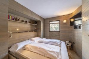 a bedroom with two beds and a television in it at Chesa Allegra - Celerina in Celerina