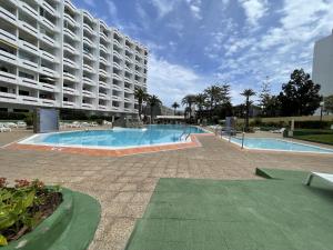 a swimming pool in front of a large building at Agaete Park 609 by Villas Rivero in Playa del Ingles