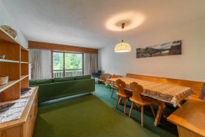 a living room with a table and a green couch at Chesa Muot Marias - Sils in Sils Maria +43 photos