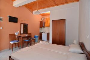 sypialnia z 2 łóżkami i biurkiem oraz kuchnia w obiekcie Avra Apartments w Limenárii