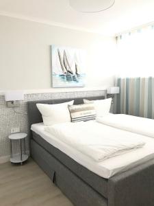 a bedroom with two beds and a painting on the wall at STRANDIDYLL, 4 - Typ A4S in Grömitz +15 photos