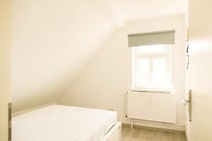 a white room with a bed and a window at Ferienwohnung Neu "Zum Westerwald" LAHN03 in Löhnberg +7 photos