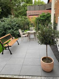 un patio con bancos, una mesa y un árbol en Mini-Ferienhaus Petersberg, en Eckernförde