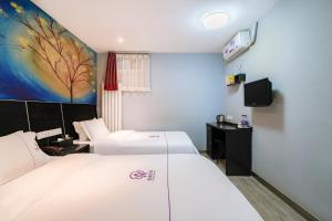 Letto o letti in una camera di Yihai Cultural Hotel Coffee, fruits, snacks, a gym and a laundry room are provided for free in the lobby