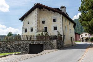 un grande edificio in pietra con un garage su una strada di Chesa Crasta - Celerina a Celerina