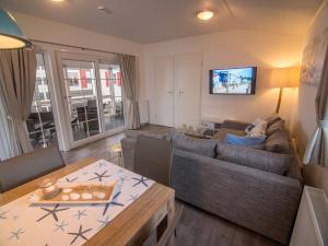a living room with a couch and a table at Strand 13 in Scharbeutz